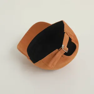 Detail of adjustable metal buckle and inner black lining on brown cotton baseball cap