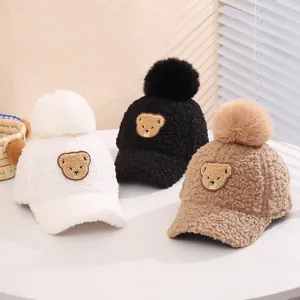 Three plush teddy bear baseball caps with pom-poms in white, black, and khaki colors