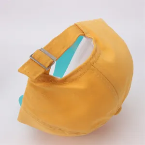 Dettaglio del cappellino giallo in cotone per coda di cavallo con fibbia in metallo