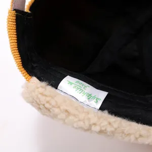 Detail of yellow corduroy and lamb wool lining on winter hat with interior wash label