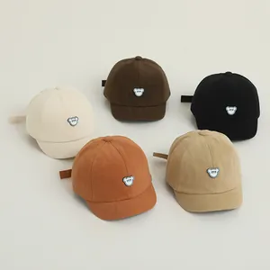 Flat lay of five cotton toddler baseball caps in beige, brown, black, and khaki colors