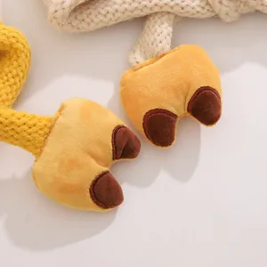 Vue détaillée des pieds de canard en peluche sur les brides de bonnet tricoté