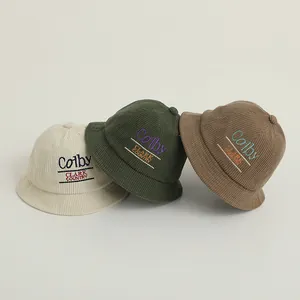 Close-up of corduroy bucket hats in beige, green, and brown with letter embroidery detail