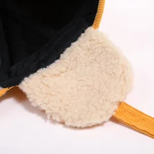 Detail of yellow corduroy winter hat with soft sherpa lining and quilted fabric