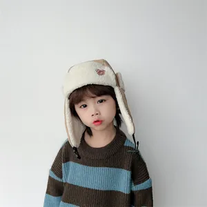 Detail of baby winter trapper hat with teddy bear embroidery and warm fleece earflaps