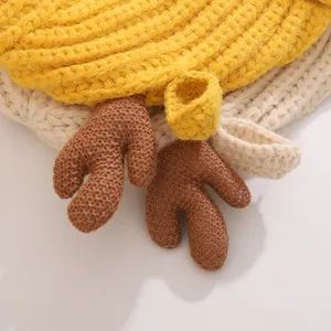 Détail de maille épaisse jaune et beige avec accents décoratifs en bois de cerf brun