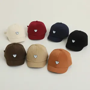 Detail view of cotton baby baseball caps in seven colors featuring cute bear patches
