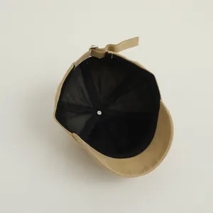 Detailed interior of khaki baseball cap featuring black sweatband and metal buckle strap