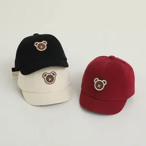 Detail shot of baby baseball caps in black, beige and burgundy with cute bear embroidery