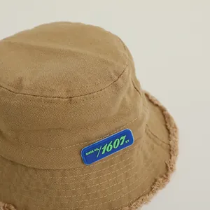 Gros plan d'un chapeau bob en velours marron avec bords usés vintage et étiquette latérale