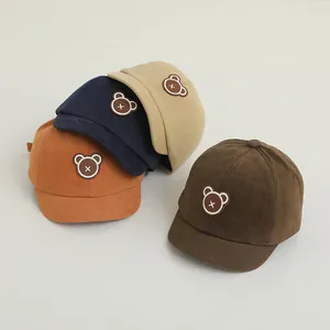 Detail of infant soft brim baseball caps with bear patches in orange, navy, beige and brown