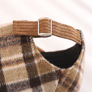Detail of adjustable metal buckle on back of plaid plush baby baseball cap
