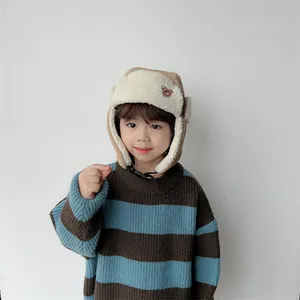 Close-up of children's corduroy winter hat featuring ear flaps and cute bear embroidery