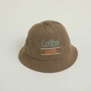 Close-up of corduroy texture and detailed Colby letter embroidery on brown kids bucket hat