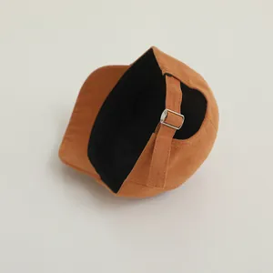 Detailed view of brown baby baseball cap featuring adjustable silver metal buckle at the back