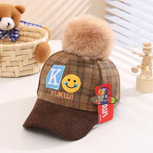 Winter kids baseball cap with brown plaid pattern, fur pompom and letter K embroidery