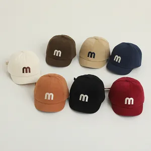 Detailed top view of soft-brim baby baseball caps with embroidered 'm' in seven colors