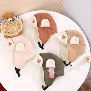 Detailed view of corduroy earflap hats with plush lining and adjustable bear logo straps