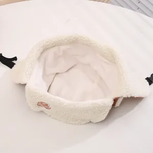 Detail of soft cream fleece lining and cute bear embroidery on toddler winter hat