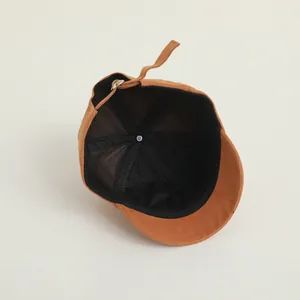 Detail of baby baseball cap interior showing black sweatband and metal adjustment buckle