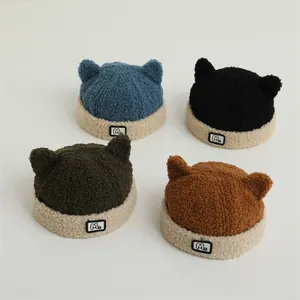 Flat lay of colorful teddy fleece hats with cute cat ears and M letter patch detail
