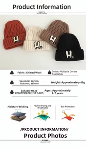 Detail view of knitted children's winter hats with H-letter and smiley face embroidery