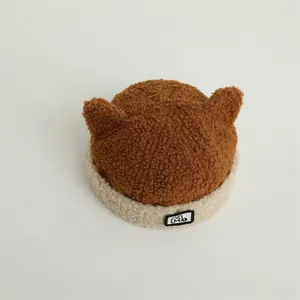 Detailed view of plush teddy fleece texture and M-label on a cute baby horn hat
