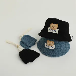 Detail of plush fleece fisherman hat and mittens set with cute bear embroidery and lucky label