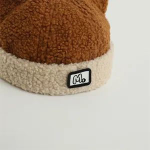 Close-up of winter fleece baby hat featuring a contrast color design and M letter patch