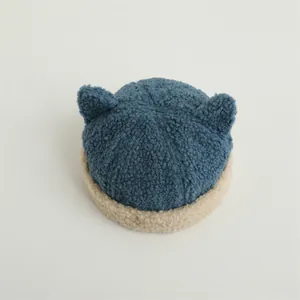 Detail view of winter fleece baby hat with soft horns and navy beige teddy plush texture