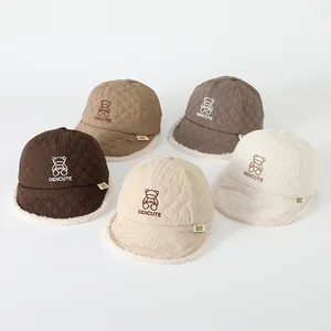 Dettaglio di cappelli invernali trapuntati con ricamo a orsetto e fodera in pile per bambini