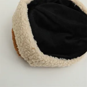 Detailed close-up of soft lamb wool fabric and stitching on a winter fleece baby hat