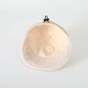 Dettaglio del cappello invernale beige per bambini con fodera in pile e fibbia regolabile