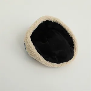 Close-up of warm beige fleece baby beanie featuring soft texture and premium black lining