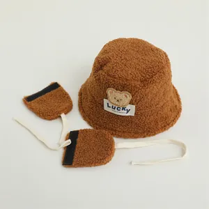 Detail of brown teddy fleece bucket hat with Lucky bear patch and matching earmuffs