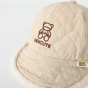 Dettaglio cappello invernale trapuntato beige con fodera morbida e orsetto ricamato