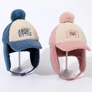 Detailed view of plush winter trapper hats for kids with ear flaps and pom-poms