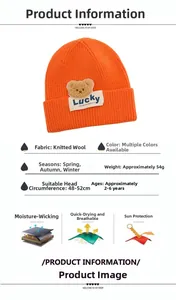 Dettaglio del cappello in maglia arancione fluo con toppa orso Lucky e specifiche tecniche