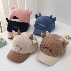 Detailed overhead view of five colorful plush baby baseball caps with cute horns