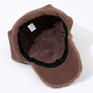 Close-up of brown corduroy aviator hat with warm fleece lining and brand care label
