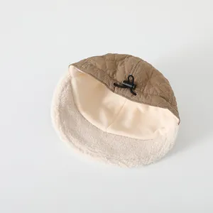 Dettaglio cappello invernale bimbi in tessuto trapuntato kaki e calda fodera in pile