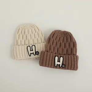 Winter ribbed knit beanie with 'H' patch and smile tag in beige and brown colors