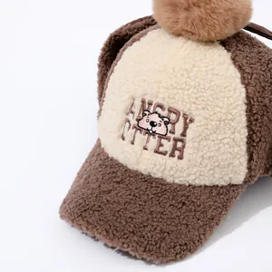 Detail of winter warm fleece baseball cap with pom-pom and Angry Otter embroidery