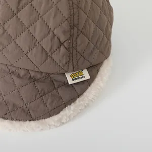 Dettaglio del cappellino bimbo trapuntato marrone con fodera interna in pile caldo