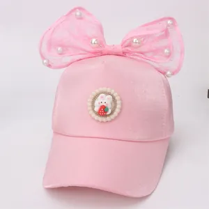 Detail van roze meisjes baseballcap met kantstrik, parels en schattig konijntje motief