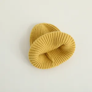 Detailansicht einer hellgelben gerippten Strickmütze mit modernem Rollrand-Design