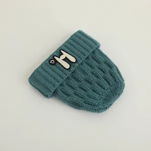 Close-up of dark teal knit beanie featuring willow grain texture and smile H patch