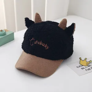 Detail of plush baby baseball cap with cute horns and Cutebaby embroidery in black and brown