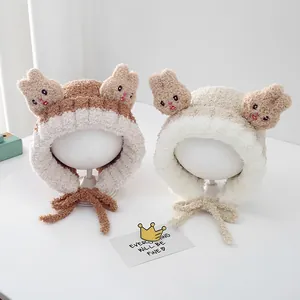 Detail view of plush rabbit ear winter hats for toddlers in brown and cream colors