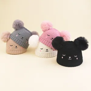 Detail of baby winter knit hats featuring soft texture and cute embroidered animal faces